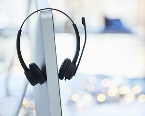 Image showing Headphones, computer and call center desk in office for telemarketing employee equipment. Contact us, tech gadget and audio support tools for help desk customer service worker on desktop monitor