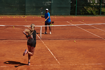 Image showing A professional tennis player and her coach training on a sunny day at the tennis court. Training and preparation of a professional tennis player