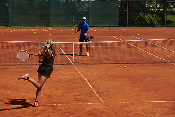 Image showing A professional tennis player and her coach training on a sunny day at the tennis court. Training and preparation of a professional tennis player