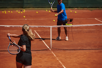 Image showing A professional tennis player and her coach training on a sunny day at the tennis court. Training and preparation of a professional tennis player