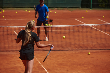 Image showing A professional tennis player and her coach training on a sunny day at the tennis court. Training and preparation of a professional tennis player