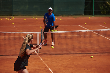 Image showing A professional tennis player and her coach training on a sunny day at the tennis court. Training and preparation of a professional tennis player