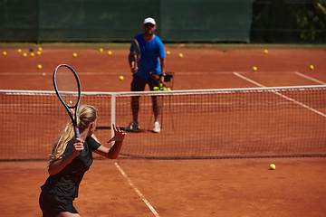 Image showing A professional tennis player and her coach training on a sunny day at the tennis court. Training and preparation of a professional tennis player