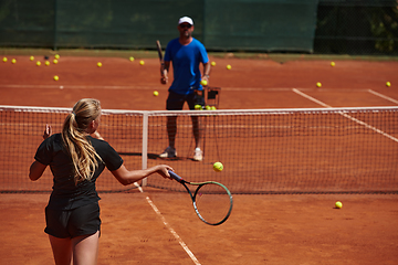 Image showing A professional tennis player and her coach training on a sunny day at the tennis court. Training and preparation of a professional tennis player