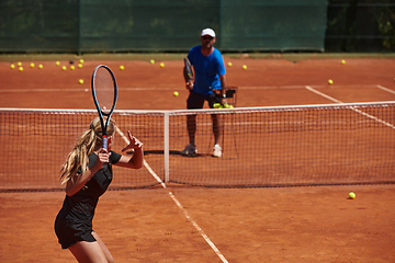 Image showing A professional tennis player and her coach training on a sunny day at the tennis court. Training and preparation of a professional tennis player