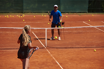 Image showing A professional tennis player and her coach training on a sunny day at the tennis court. Training and preparation of a professional tennis player