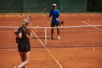 Image showing A professional tennis player and her coach training on a sunny day at the tennis court. Training and preparation of a professional tennis player