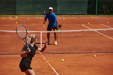 Image showing A professional tennis player and her coach training on a sunny day at the tennis court. Training and preparation of a professional tennis player