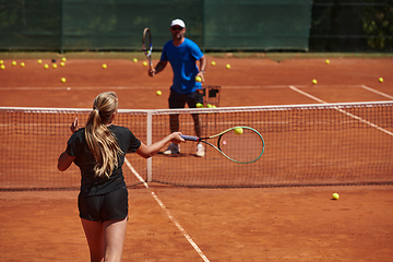 Image showing A professional tennis player and her coach training on a sunny day at the tennis court. Training and preparation of a professional tennis player