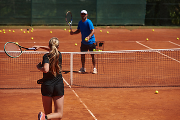 Image showing A professional tennis player and her coach training on a sunny day at the tennis court. Training and preparation of a professional tennis player