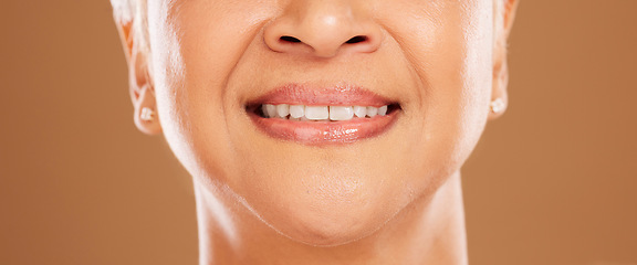 Image showing Teeth, dental and senior woman in studio isolated on a brown background. Oral care, wellness or closeup smile of elderly female model with natural looking veneers for beauty and healthy tooth hygiene