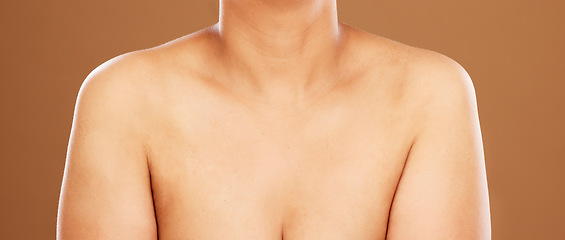 Image showing Woman, chest and skincare on a brown studio background for health, wellness and breast cancer awareness. Human body, skin and bust of a female model posing naked for healthcare and self care