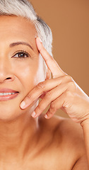 Image showing Old woman, beauty and half face portrait in studio isolated on a brown background. Luxury makeup, cosmetics and retired elderly female model thinking about facial skincare, health and skin wellness.