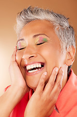 Image showing Happy, color and senior woman with makeup standing in a studio with colorful, trendy and edgy cosmetics. Happiness, smile and elderly lady with a beauty routine isolated by gradient brown background.