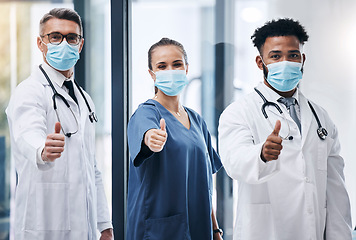 Image showing Hospital, team and thumbs up for medical support in healthcare success. Mask, yes and covid safety compliance winner or clinic teamwork happiness in doctor laboratory office for clinical achievement