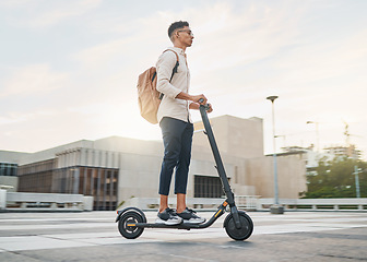 Image showing Young man, riding scooter and eco friendly for emission free future, sustainable and outdoor. Travel, casual business man and driving electric transport in city street, during day commute or journey