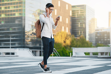 Image showing Phone, music and city with a man student walking to university or college during his morning commute. Headphones, social media and 5g mobile technology with a male pupil in an urban town for a walk