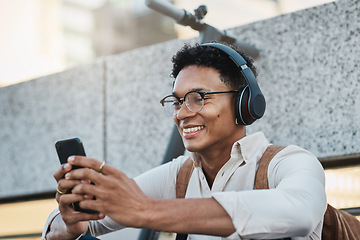 Image showing Music, phone and city with a business black man streaming or listening to music while networking. Schedule, mobile and street with a male employee using headphones to stream audio in an urban town