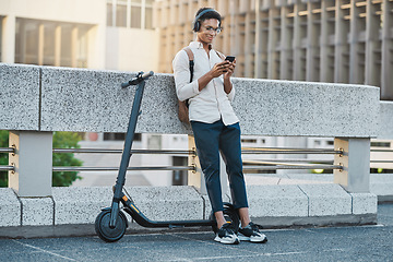 Image showing Phone, music and electric scooter with a business black man streaming audio during his commute into work. Mobile, headphones and transport with a male employee typing a text message in an urban town