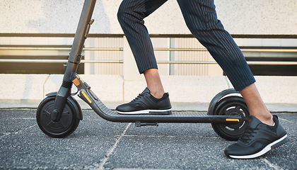 Image showing Electric scooter, fashion and travel on a city street with black sneakers, energy and modern tech for eco friendly transportation. Future, hipster and energy of urban male legs on e scooter vehicle