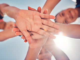 Image showing Hands, teamwork and collaboration of friends, community or people together for charity, support and motivation outdoor with lens flare. Group together for trust, commitment and synergy from below