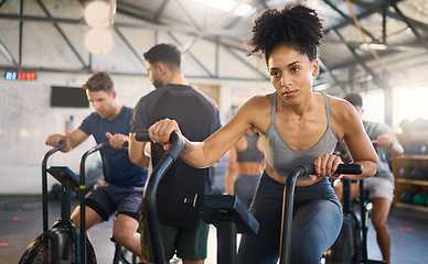 Image showing Fitness, class and bike workout of a black woman in a cycling, training and exercise studio. Bicycle sport, gym wellness and sports health club with a person on a machine with athlete motivation