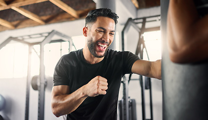 Image showing Boxing gym, fitness and happy athlete boxer punching a training bag in a martial arts studio or club. Happiness of a man in a fight workout and sport exercise with a smile about healthy cardio