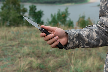 Image showing A man with a knife in the forest.