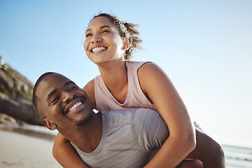 Image showing Black couple, beach and fitness with a piggy back ride for fun, energy and freedom while on vacation with happiness, love and support. Smile of man and woman on holiday by sea for a fun, summer