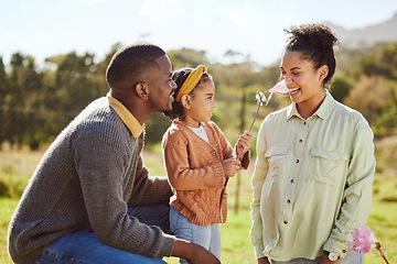 Image showing Happy family, countryside fun and child with flower tickle moms nose, play or enjoy outdoor quality time together. Love, nature freedom and spring peace for kid girl, parents or bonding black family