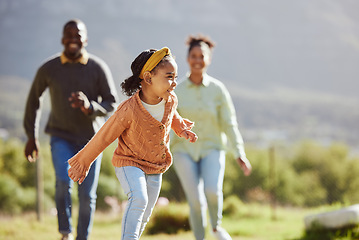 Image showing Black family, fun child and parents running, chasing and enjoy bonding quality time with youth kid on countryside vacation. Love, peace and freedom for happy girl, father and mother playing outdoor