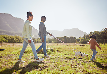 Image showing Nature, pet and black family taking a walk with dog having fun, bonding and enjoying summer. Love, animals and mom and dad walking with young girl and puppy in park on weekend, holiday and vacation