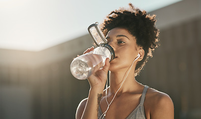 Image showing Fitness, drinking water and black woman listening to music for workout motivation, wellness and healthy lifestyle in morning city. Sports, runner girl outdoor with water bottle and exercise audio