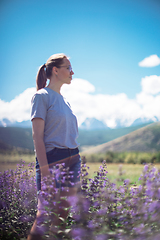 Image showing Happy young woman in beautiful wild pink and purple flowers field