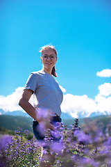 Image showing Happy young woman in beautiful wild pink and purple flowers field