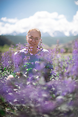 Image showing Happy young woman in beautiful wild pink and purple flowers field