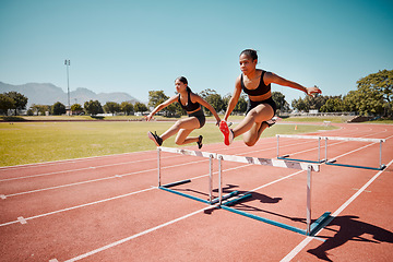 Image showing Sport, jump and women runner doing hurdles on stadium track, athlete running race and fitness training outdoor. Practice, workout and sports, speed and agility for exercise and cardio motivation.