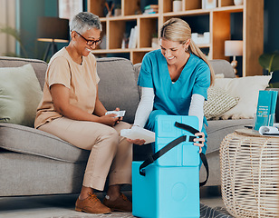 Image showing Doctor, senior woman and home with medicine, box or delivery for healthcare, wellness or consulting on sofa. Patient, smile or medical conversation with nurse in living room at house for health pills