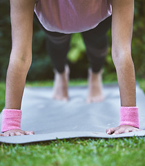 Image showing Yoga, hands and mat with a woman plank closeup outdoor in a grass park for workout or training. Wellness, health and fitness with a female yogi exercising outside on grass in a garden for balance