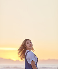 Image showing Travel, sunset and smile with asian woman at beach with mockup for summer, freedom and vacation. Happy, heath and wellness with girl and relax by the ocean for peace, nature and sky on holiday