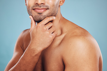 Image showing Hand, skincare and beauty with a man model in studio on a blue background thinking about grooming. Wellness, cosmetics and skin with a male posing to promote a natural product or antiaging treatment