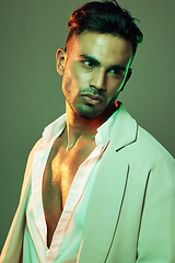 Image showing Green light, fashion and man in studio isolated on a green background. Beauty, neon light and male model from Brazil with idea, thinking or contemplating about cool designer jacket or stylish outfit.