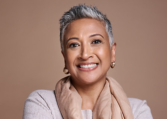 Image showing Face, fashion and senior woman in studio isolated against a brown background. Beauty portrait, smile and makeup cosmetics or aesthetics of happy elderly model from India in designer scarf or clothes.