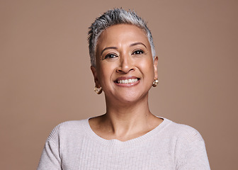 Image showing Face, beauty and portrait of a senior woman with a smile standing with natural makeup in studio. Wellness, cosmetics and happy elderly lady with healthy skin posing while isolated by brown background