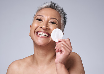 Image showing Woman, elderly and beauty portrait with cotton pad for cosmetic, makeup and product removal on face. Cleaning, facial and skincare cleansing model happy with mature skin in mock up gray studio.