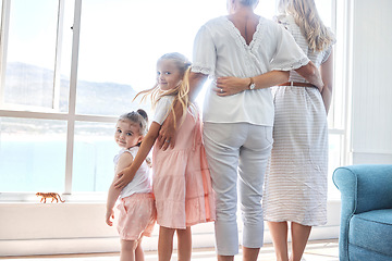 Image showing Girl, family and window in a living room of holiday house, bonding and relax while enjoying the view together. Vacation, home and happy kids, mother and grandmother and scenic view on beach in summer