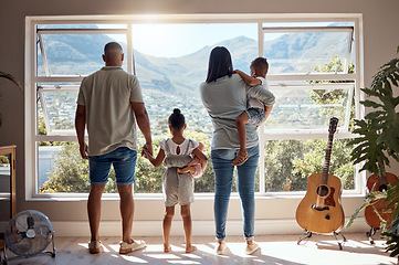 Image showing Family, love and window back view in home looking at mountain. Support, trust and baby, mother and father holding hands of girl in house with scenic view, enjoying quality time together and bonding.