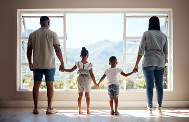 Image showing Love, back view and family holding hands by window looking at scenic view of nature, trees and mountain. Bonding, affection and mom and dad standing with kids in new apartment, happy in family home