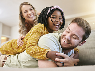 Image showing Adoption, love and family play, hug and happy smile, care and laugh together on the sofa in living room. African child, mother and father with happiness, fun and laughing on the couch in family home