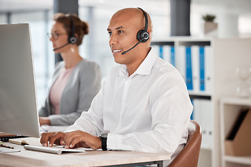 Image showing Call center, customer service and support with a man consultant working on a computer in his sales office. Retail, ecommerce and communication with a male consulting using a headset for help